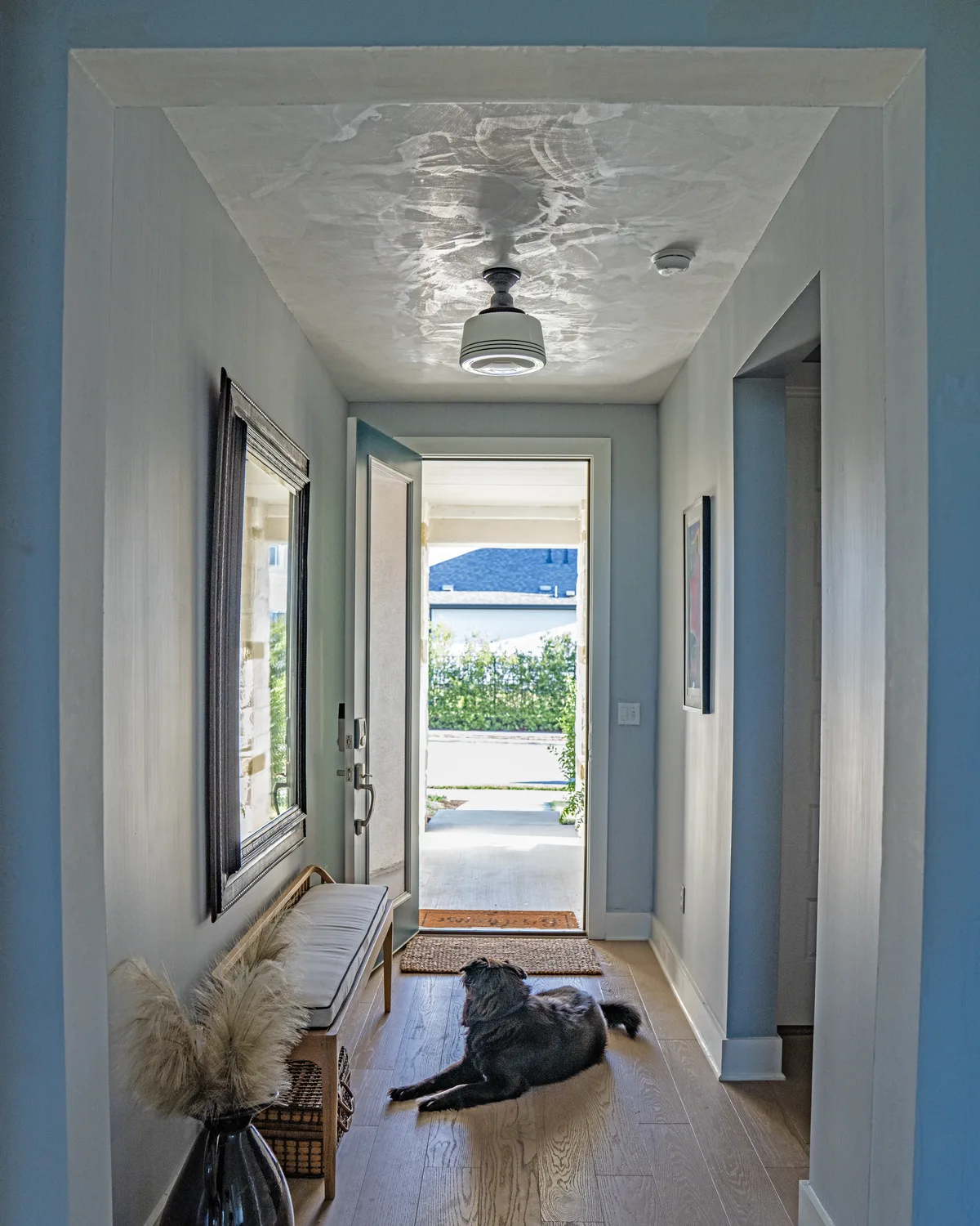 Burnished Marmorino ceiling in a white entry hall, trowel movement catching the light